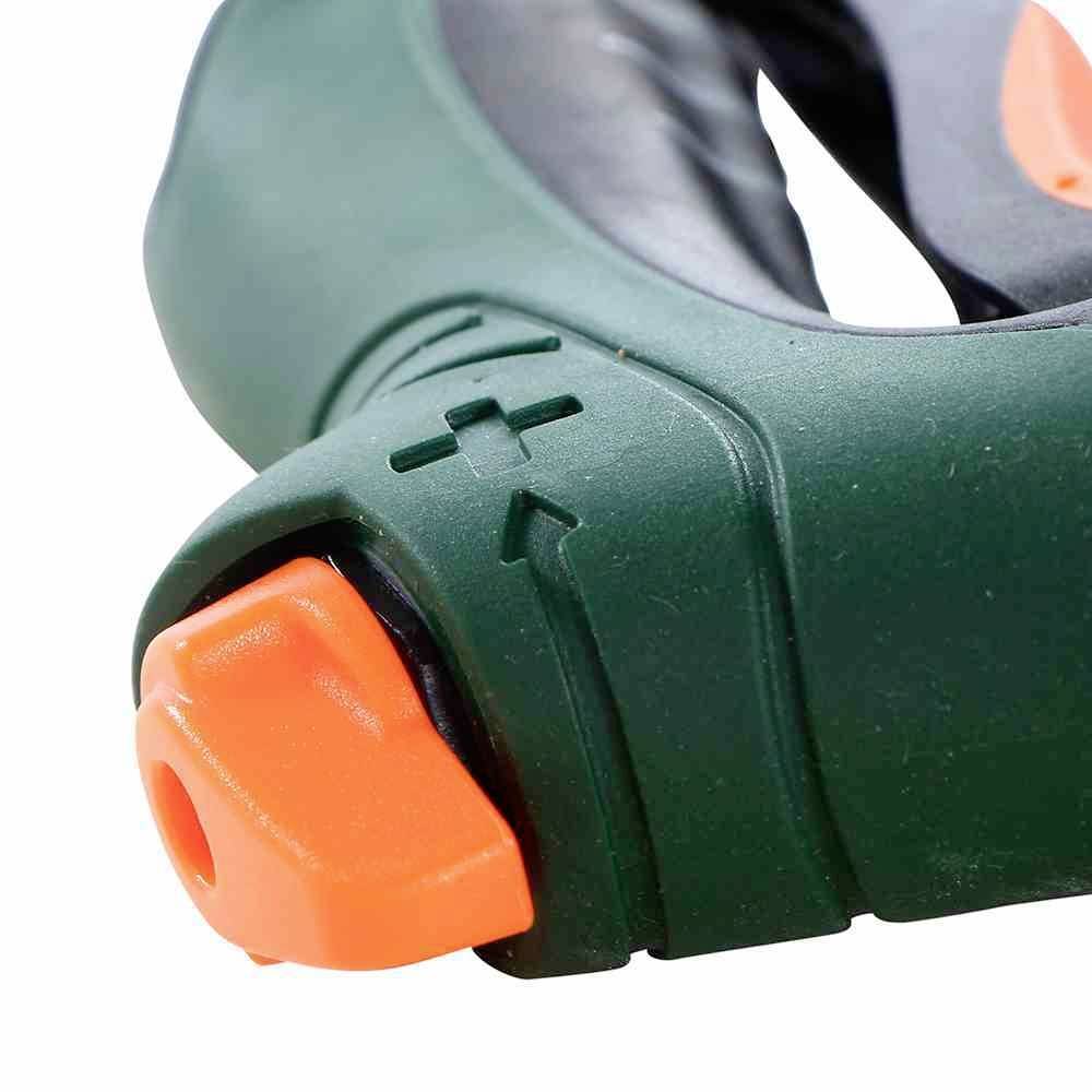 Primo piano di un ugello di un tubo da giardino verde con valvola di regolazione arancione e segni più e meno per la regolazione del flusso d'acqua.