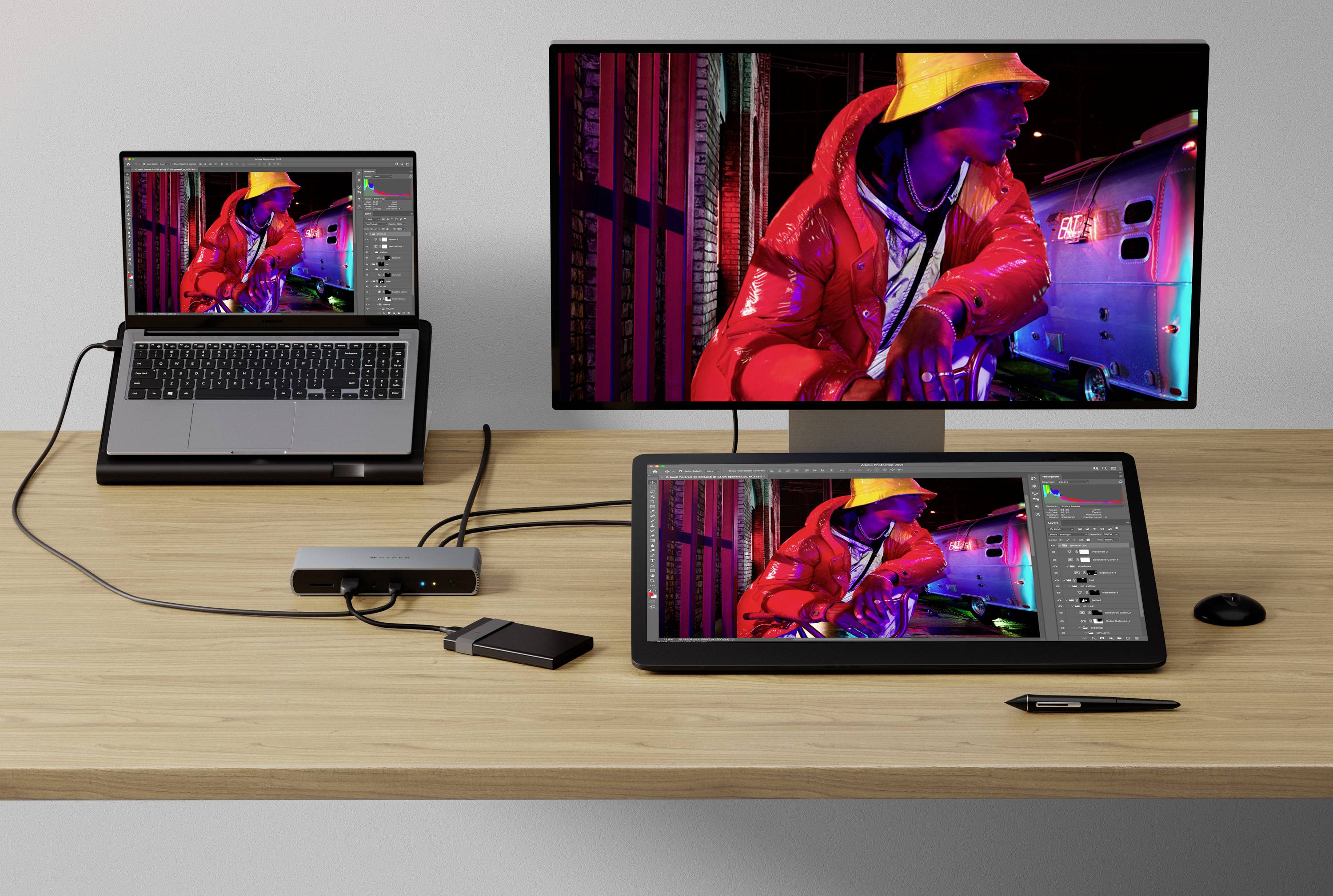 Una scrivania con un computer, una tavoletta grafica e un monitor. Tutti i dispositivi mostrano la stessa immagine colorata di un artista di graffiti.