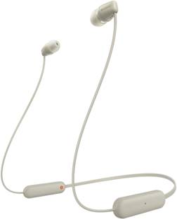 Auricolari wireless beige con cavo di connessione tra i due padiglioni. A sinistra è presente una piccola luce rossa.