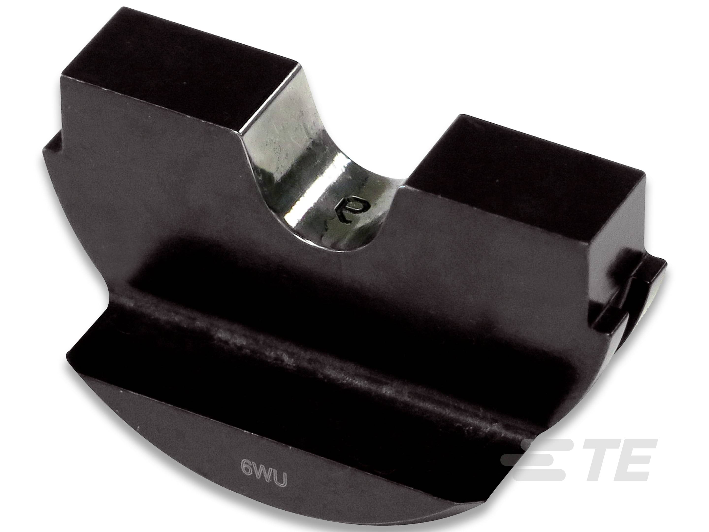 Un componente nero e metallico a forma di semicerchio con superficie liscia, probabilmente una morsetta o un supporto.