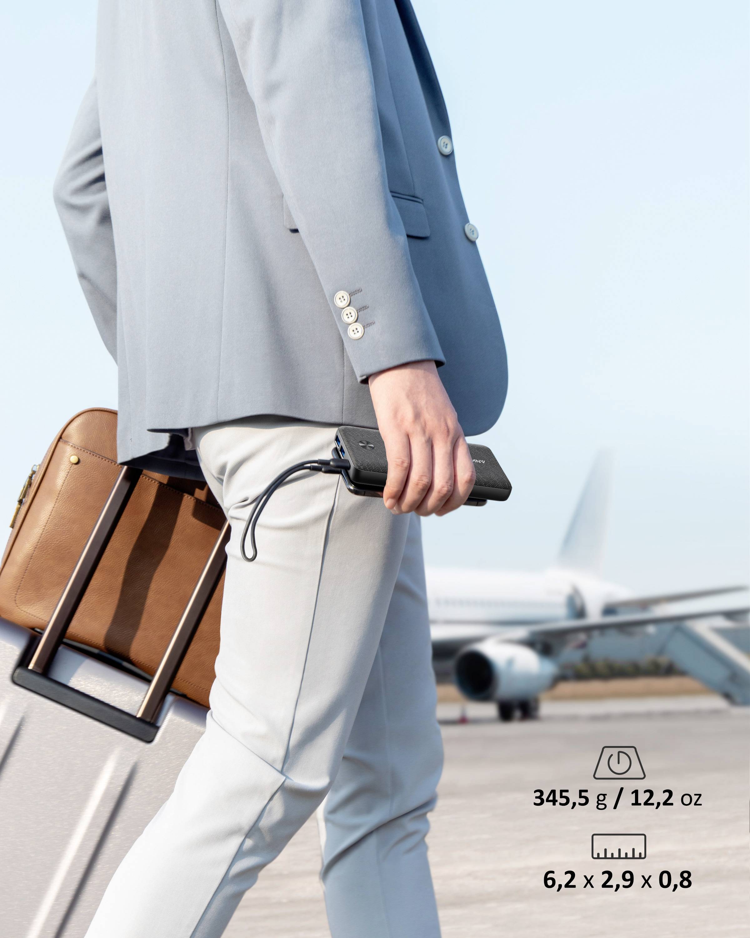 Persona in tailleur azzurro chiaro trascina una valigia in aeroporto; sullo sfondo un aereo. Testo a sinistra: '345,5 g / 12,2 oz, 6,2 x 2,9 x 0,8'.