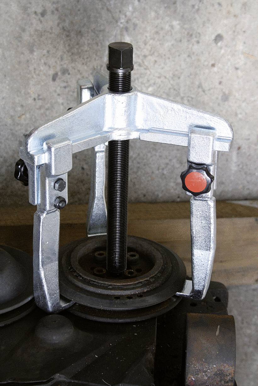 Un 'estrattore metallico', fissato a un componente del motore, viene utilizzato per rimuovere parti bloccate come cuscinetti o ingranaggi.