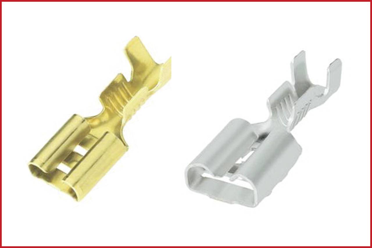 Due capicorda non isolati in oro e argento su sfondo bianco. Sono utilizzati per il collegamento elettrico dei cavi.