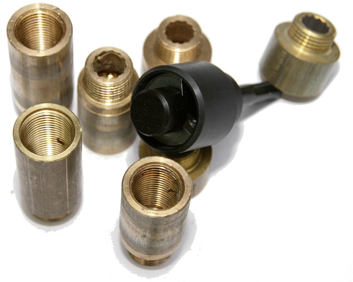 'Boccole in ottone e un accessorio per utensili nero giacciono su uno sfondo bianco. Sette boccole sono distribuite intorno all'utensile.'