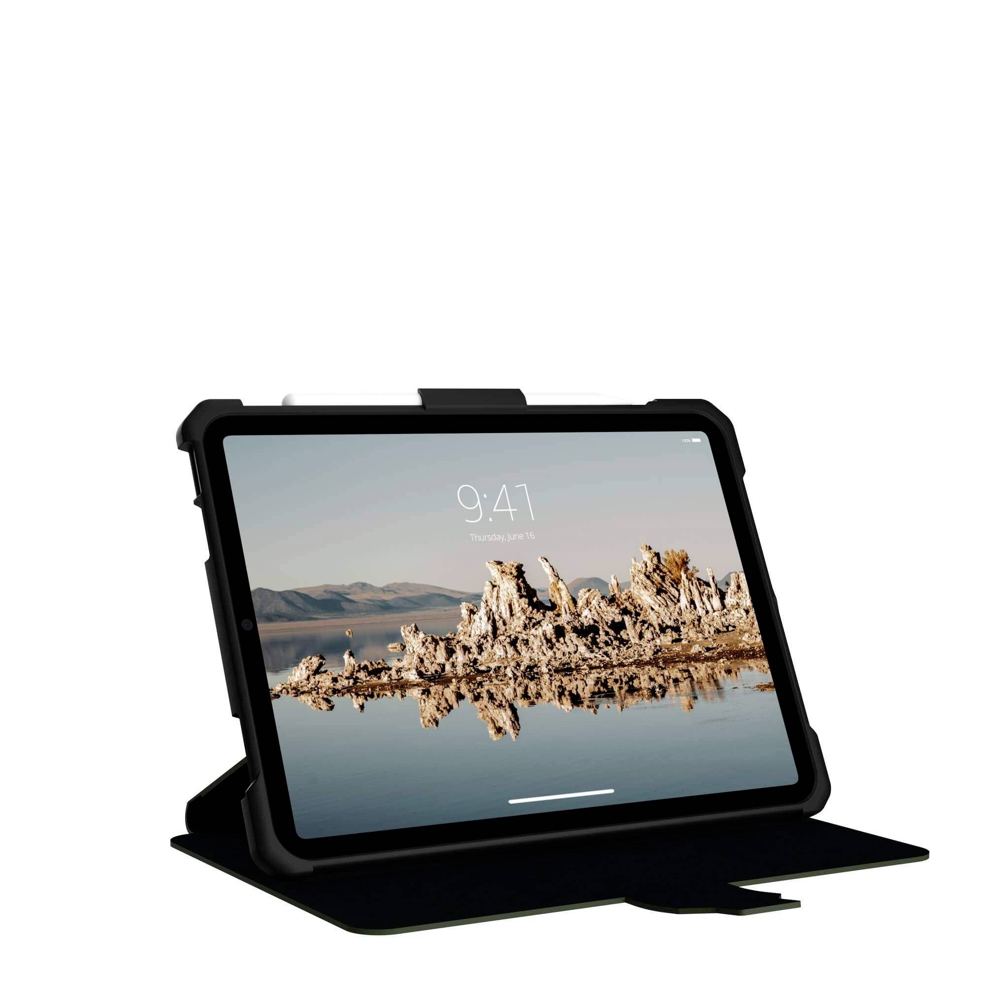 Un tablet in un custodia nera è in piedi in posizione verticale. Sullo schermo è visibile un paesaggio con rocce e acqua.