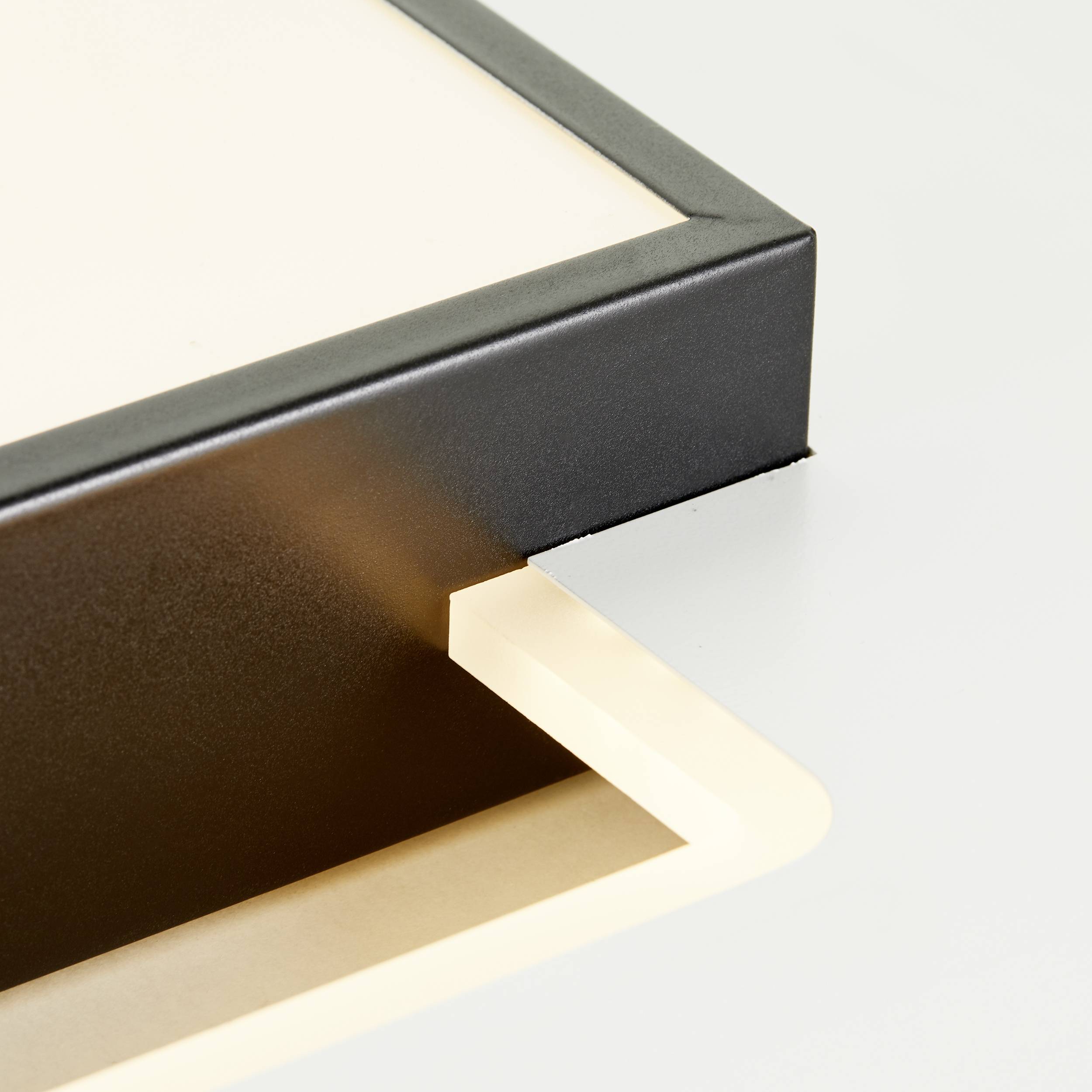 Primo piano di una copertina posteriore di un libro nero aperta, con una pagina leggermente beige che sporge, creando un'ombra.