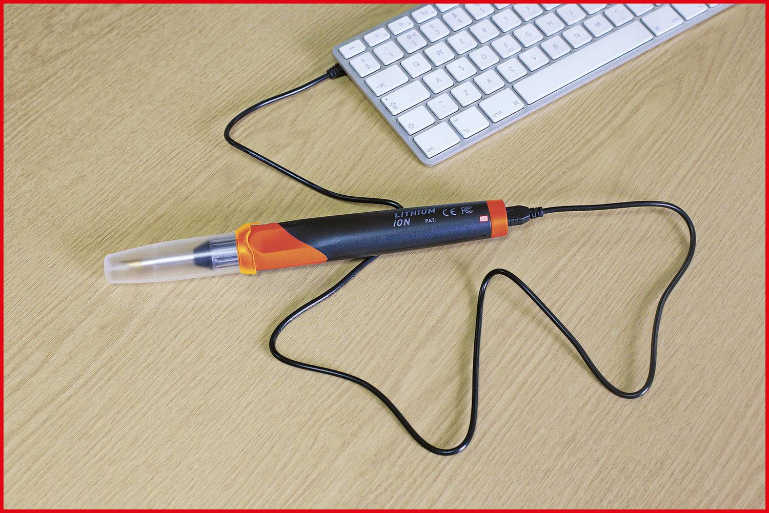 Una penna elettronica, collegata a una tastiera per computer, è posizionata su una scrivania.