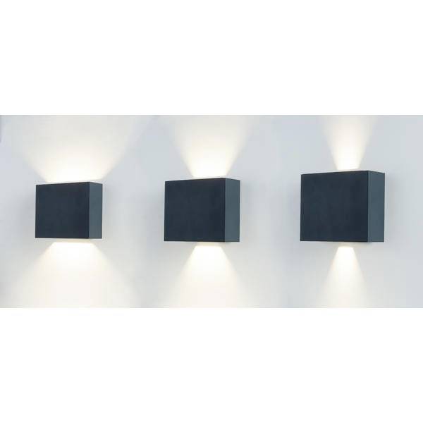 Tre applique rettangolari montate sul muro bianco che proiettano luce verso l'alto e verso il basso, distribuite uniformemente e che forniscono illuminazione.