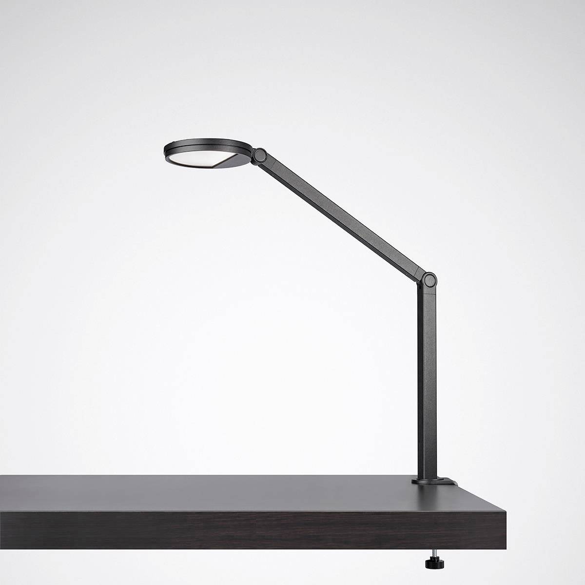 Una moderna lampada da scrivania nera con un braccio lungo e snodabile, posizionata su un tavolo nero. Design minimalista.