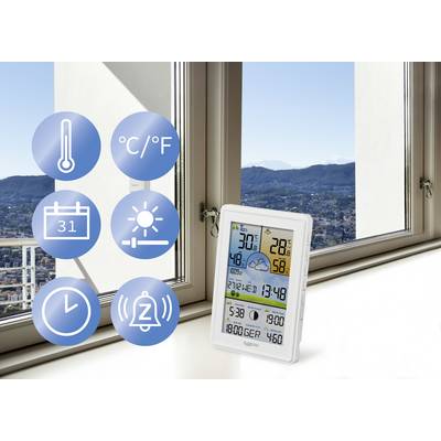 Stazione meteorologica digitale sul davanzale che mostra temperatura, umidità e previsioni meteo. Icone per temperatura, data, ora, allarme. Finestra con vista panoramica sulle montagne sullo sfondo.
