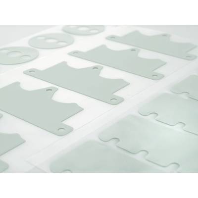 Diversi pezzi rettangolari in plastica grigia con fori circolari sono disposti in file ordinate su fogli bianchi.