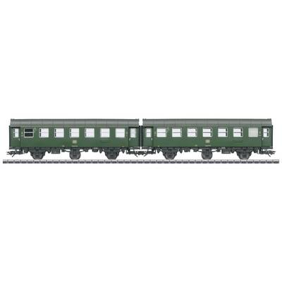 Due vagoni ferroviari storici verdi sono fermi sullo stesso binario. Sono visibili file di finestrini. Ricordano i treni passeggeri di un tempo.