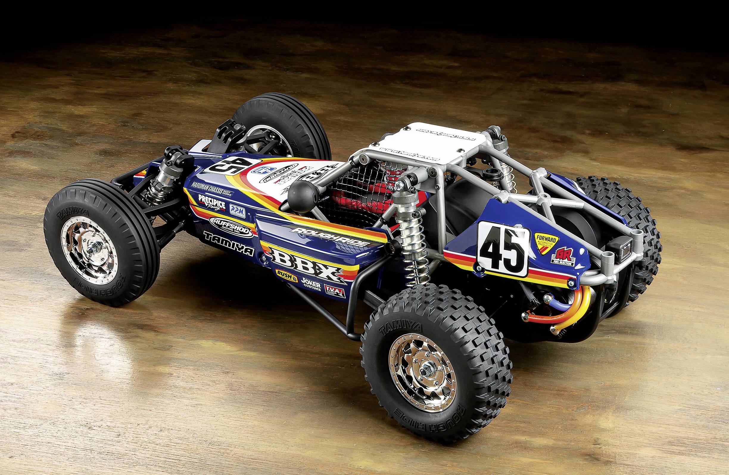 Un modellino di auto dettagliato, in stile buggy fuoristrada, su un pavimento di legno. Mostra il numero 45 ed è colorato in modo vivace.