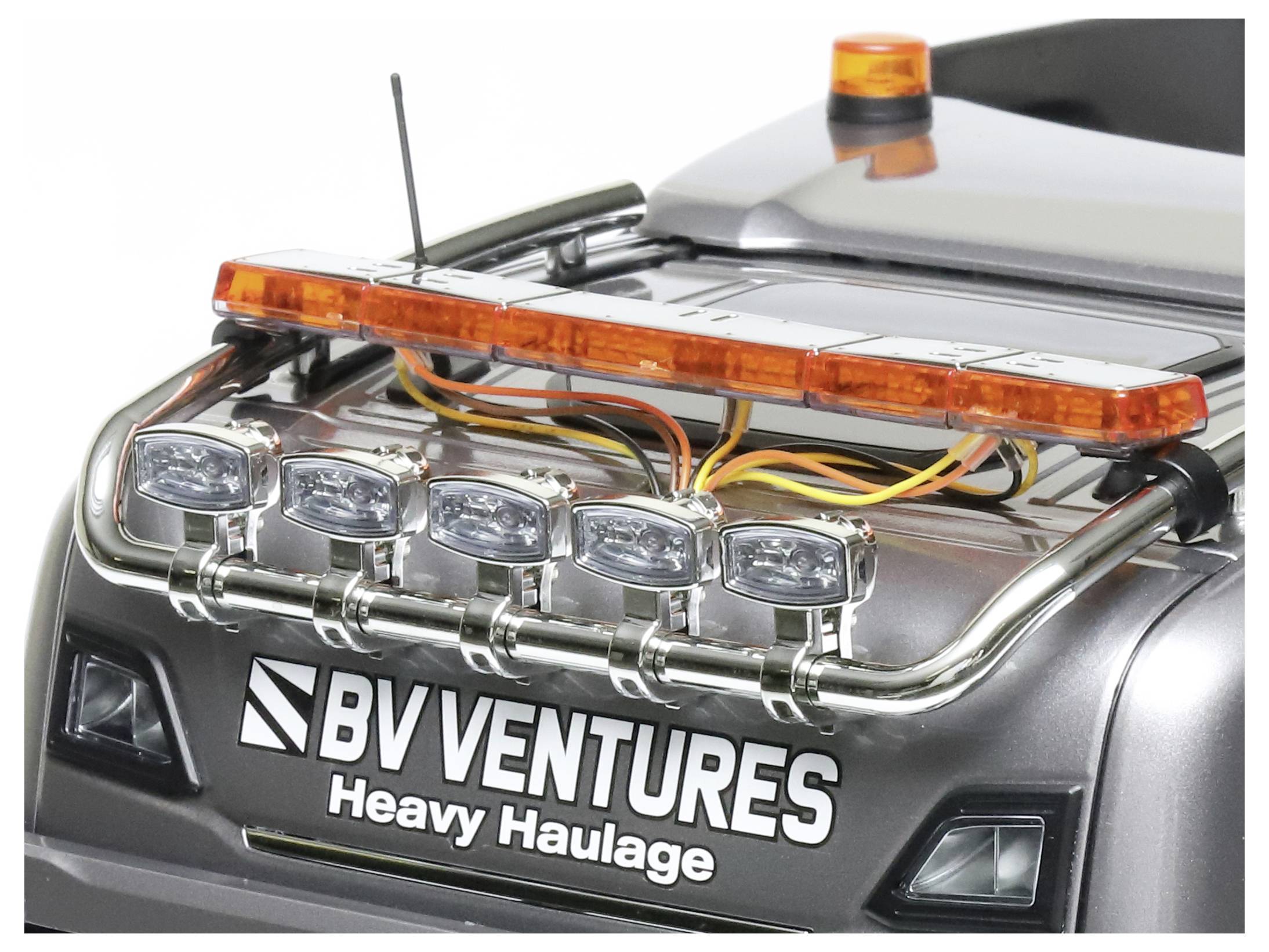 Camion giocattolo con scritta 'BV Ventures Heavy Haulage' sul retro, luce di avvertimento arancione in alto, fari argentati.