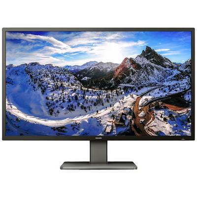Un grande monitor mostra un paesaggio innevato in montagna al tramonto, con strade e case sparse sullo sfondo.