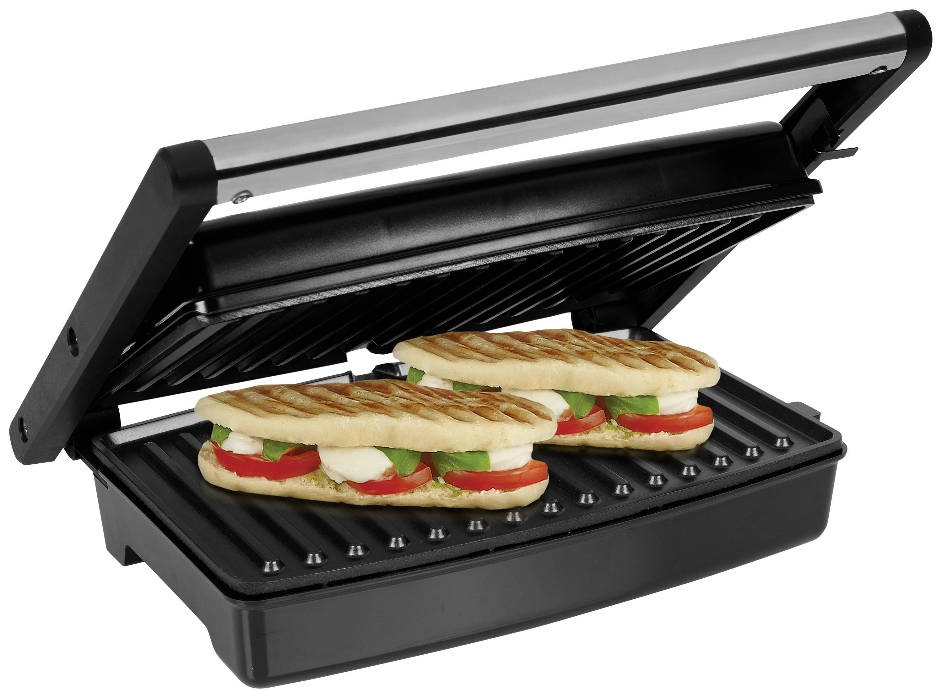 Due panini con pomodori, mozzarella e basilico vengono riscaldati su una piastra grill.