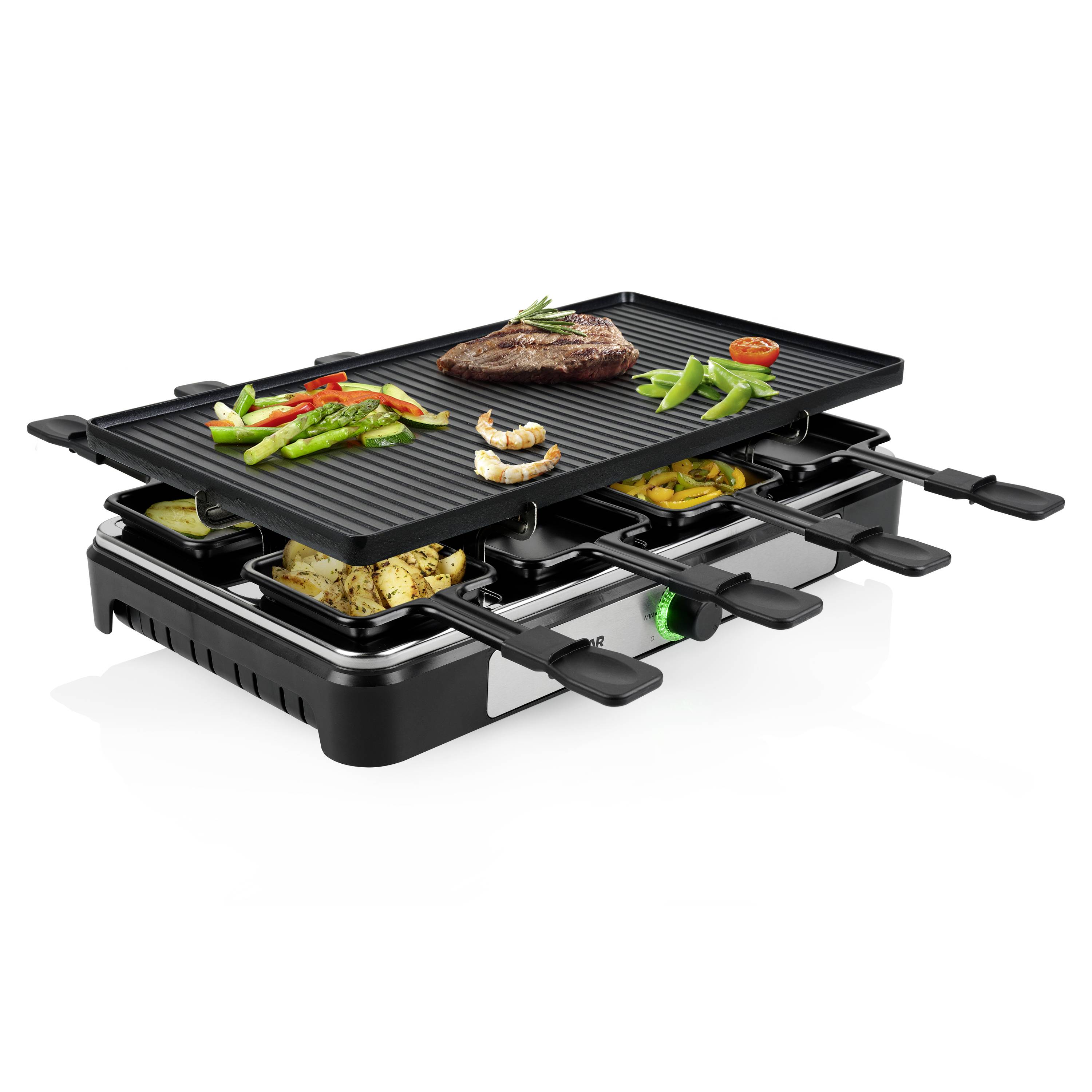 Un grill elettrico per raclette, con piastra superiore per grigliare bistecca e verdure; sotto piccole padelle con formaggio fuso e contorni.