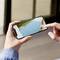 Una persona tiene uno smartphone che mostra un'app di Realtà Aumentata (AR). L'app misura un rettangolo sul pavimento, probabilmente per lavori domestici.