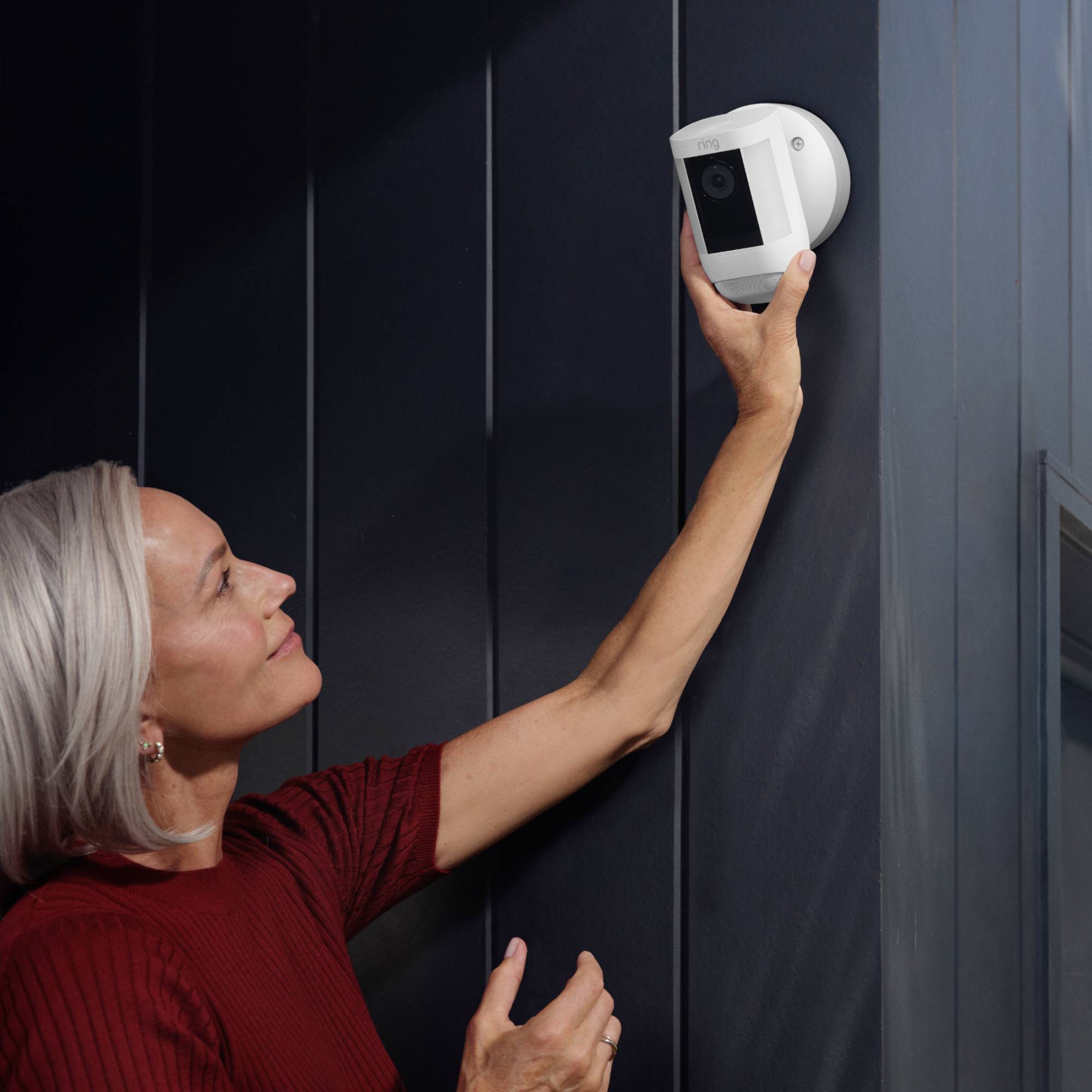 Una donna sta montando una telecamera di sicurezza su una parete.