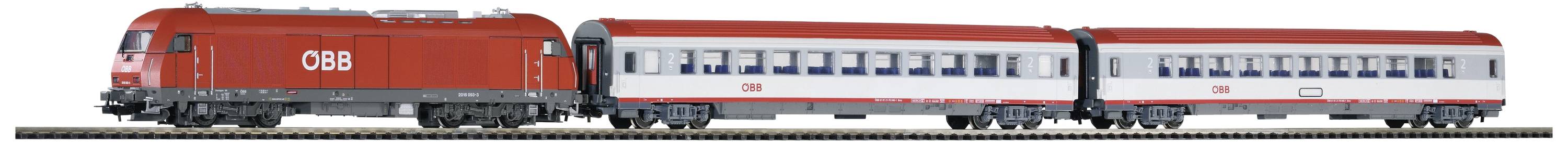 Un treno rosso delle ÖBB con due carrozze sta viaggiando su un binario. Le carrozze sono bianche con finestrini blu.
