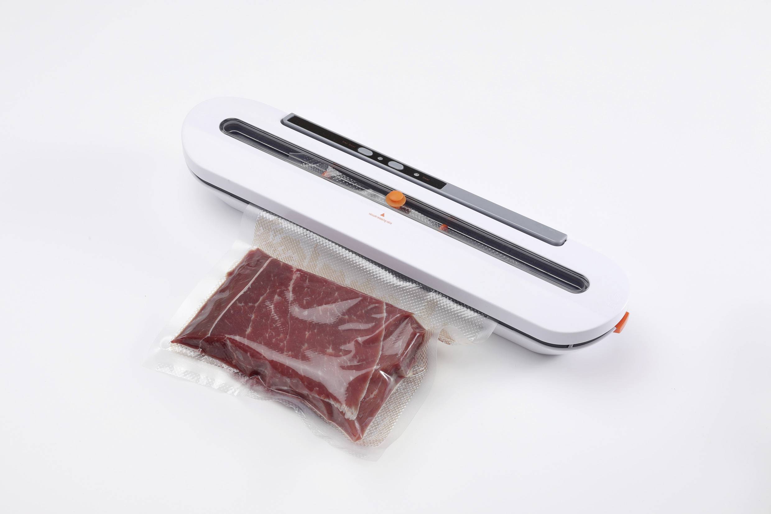 Sigillatura sottovuoto di un pezzo di carne con un dispositivo di sigillatura bianco su sfondo bianco.