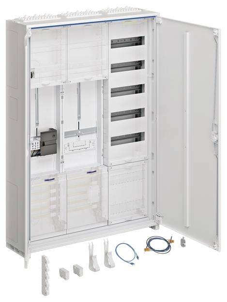 Armadio elettrico aperto con cavi e spine sul pavimento. Contiene scomparti e dispositivi per installazioni elettriche. Porta aperta sulla destra.