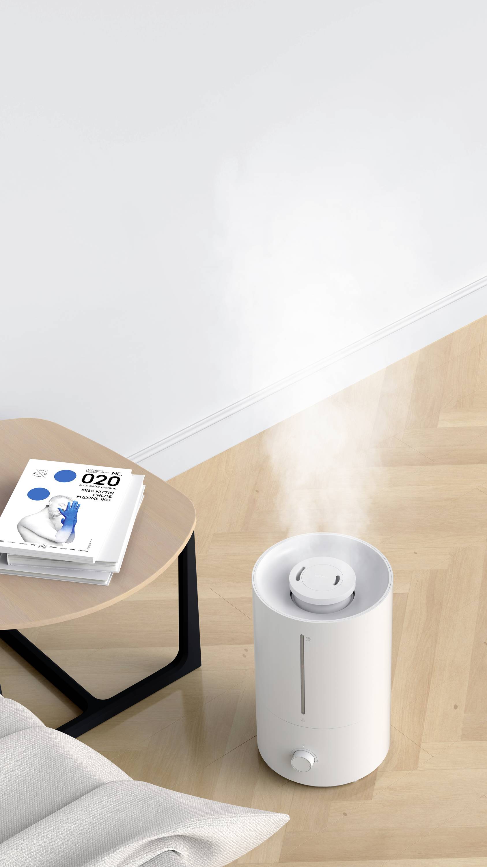 Un umidificatore bianco emana vapore su un pavimento in legno. Accanto a esso c'è un piccolo tavolo con un libro sopra.