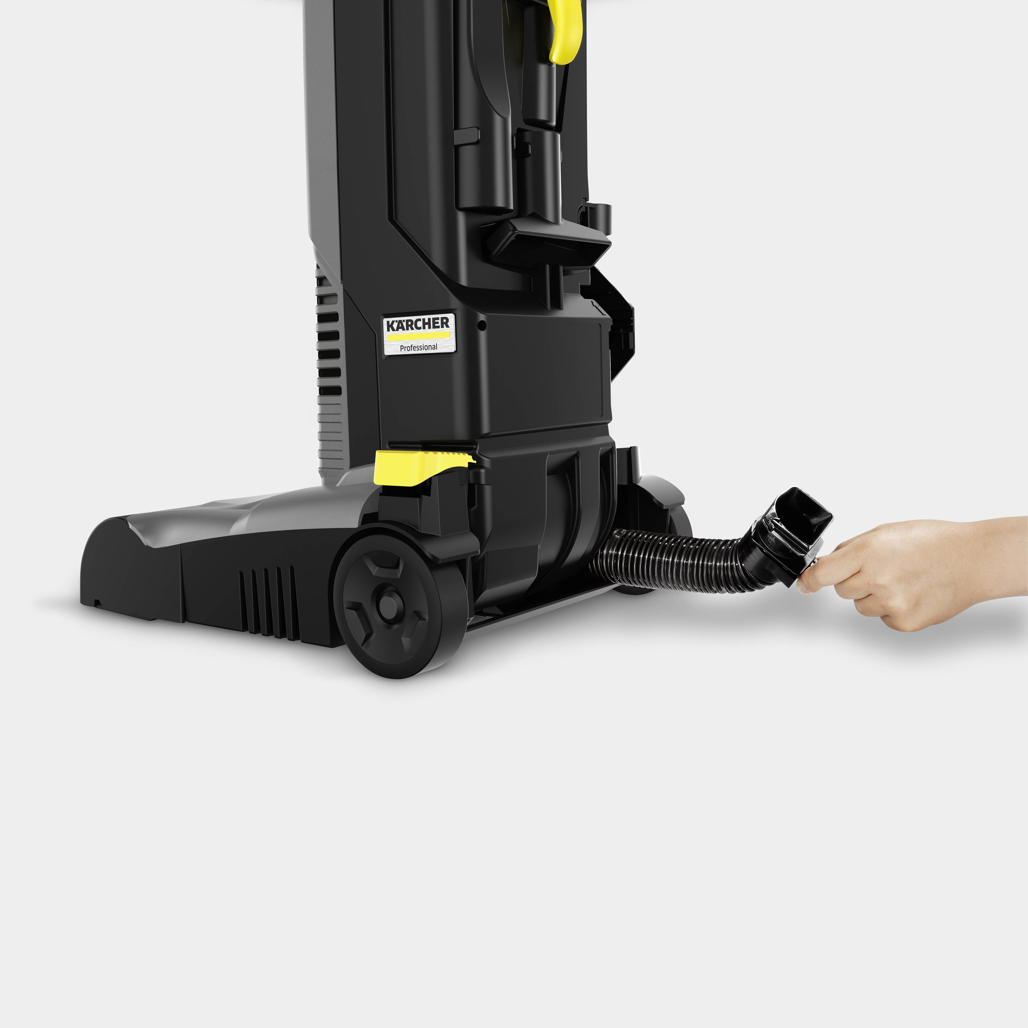 Aspirapolvere in vista laterale con design giallo e nero, mano destra che impugna il tubo, focus sull'ergonomia.