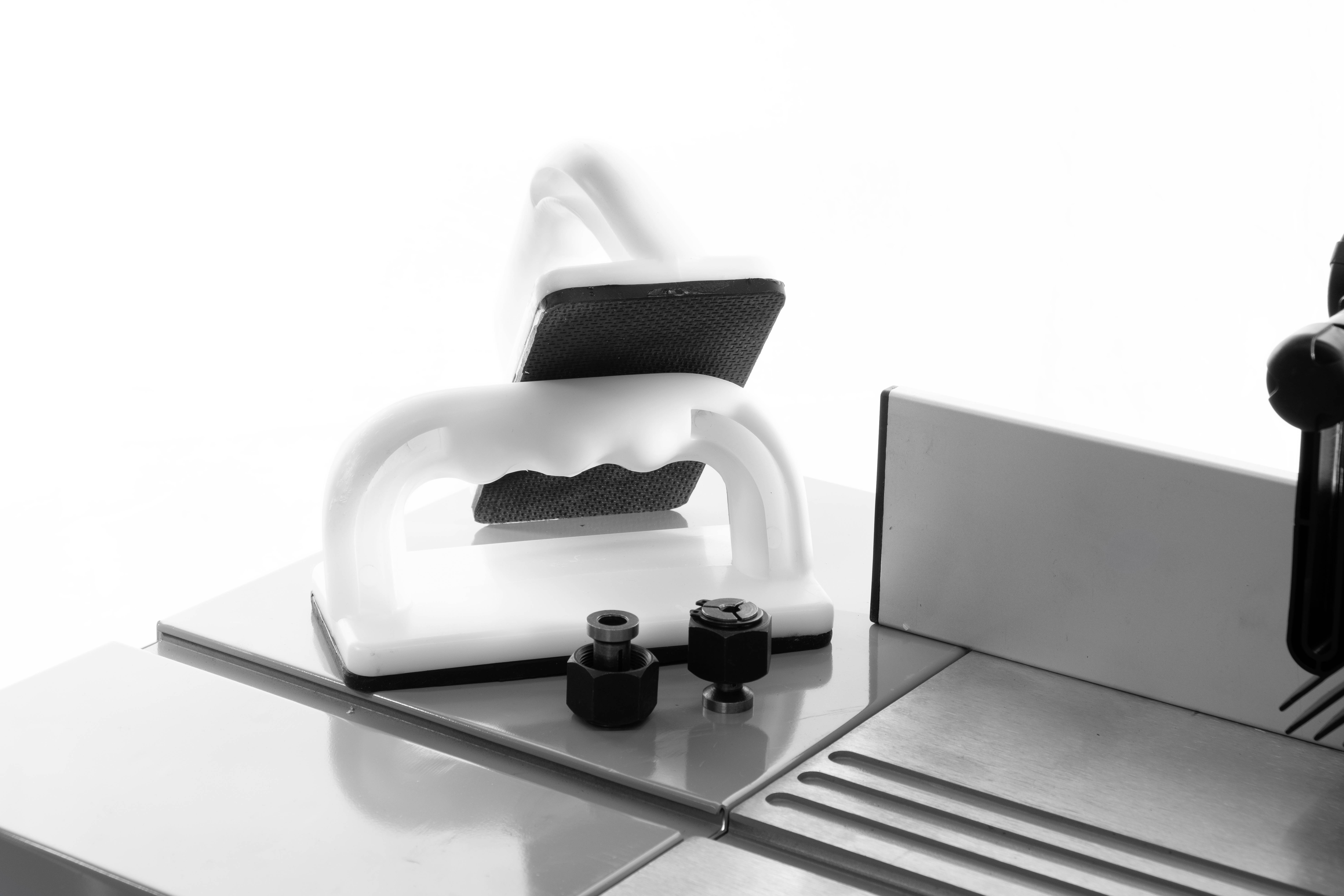 Un supporto ergonomico scorrevole su un tavolo per la lavorazione del legno, atto ad aumentare la sicurezza durante il lavoro con una sega.