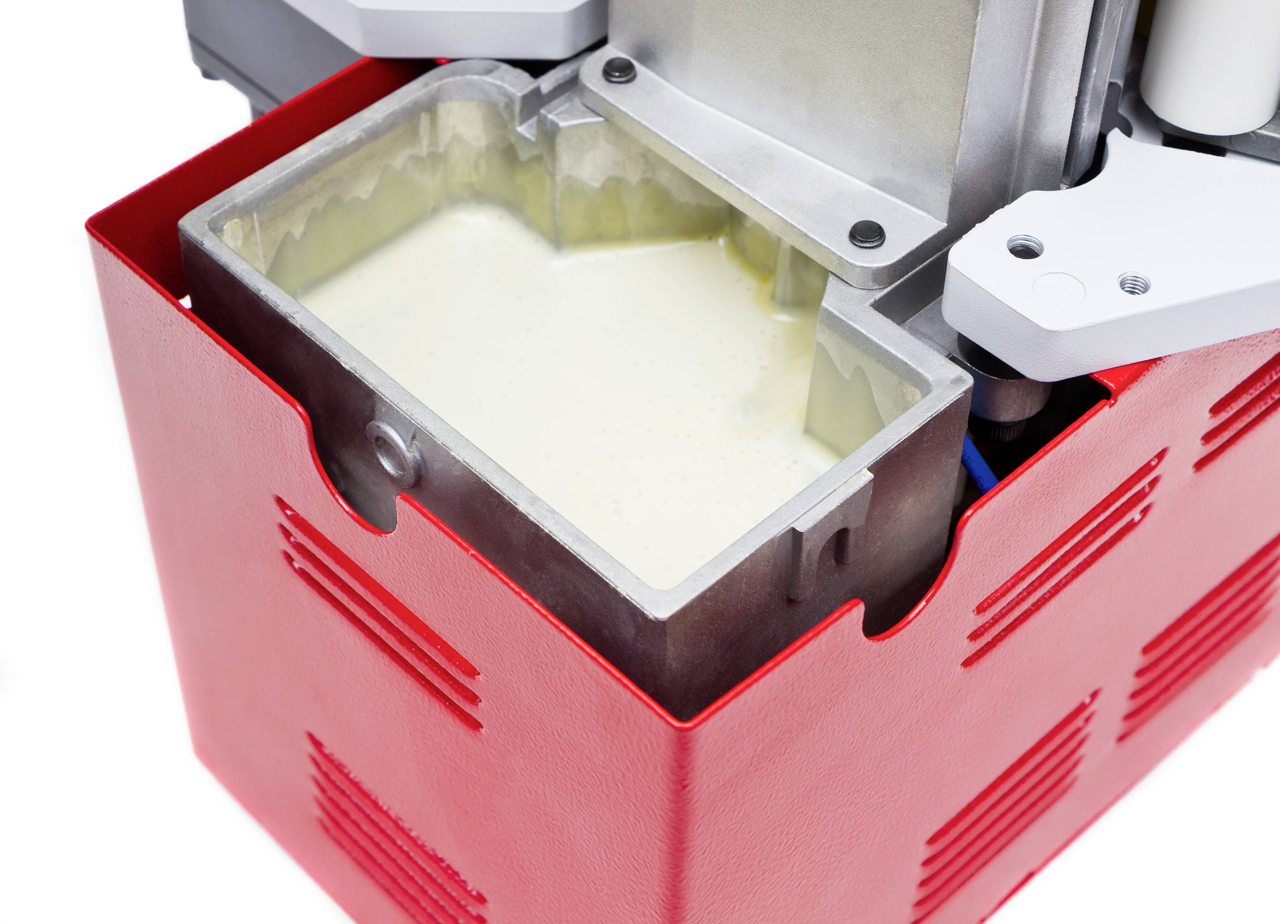 Un maker di gelato rosso con una ciotola aperta riempita di gelato alla vaniglia pronto.