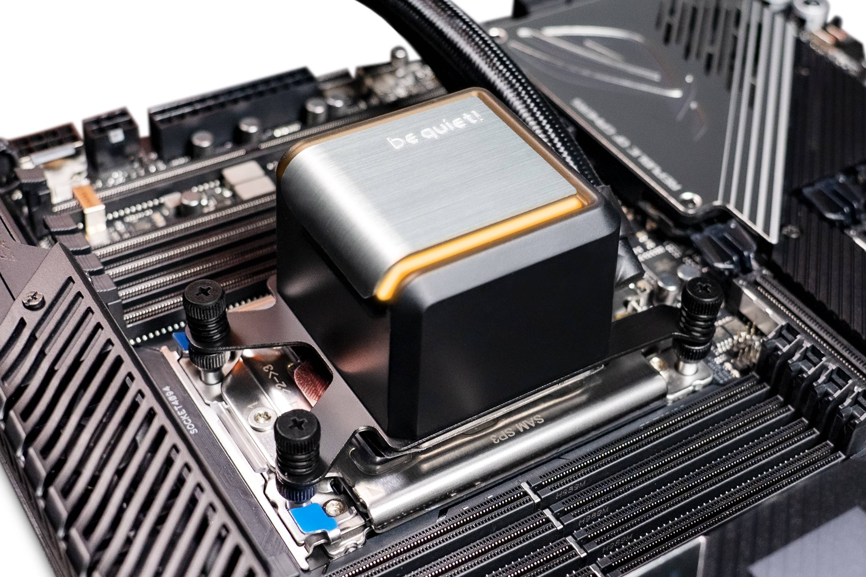 Primo piano di una scheda madre per computer con un grande dissipatore di calore della CPU nero del marchio 'be quiet!' e dettagli dei componenti elettronici.