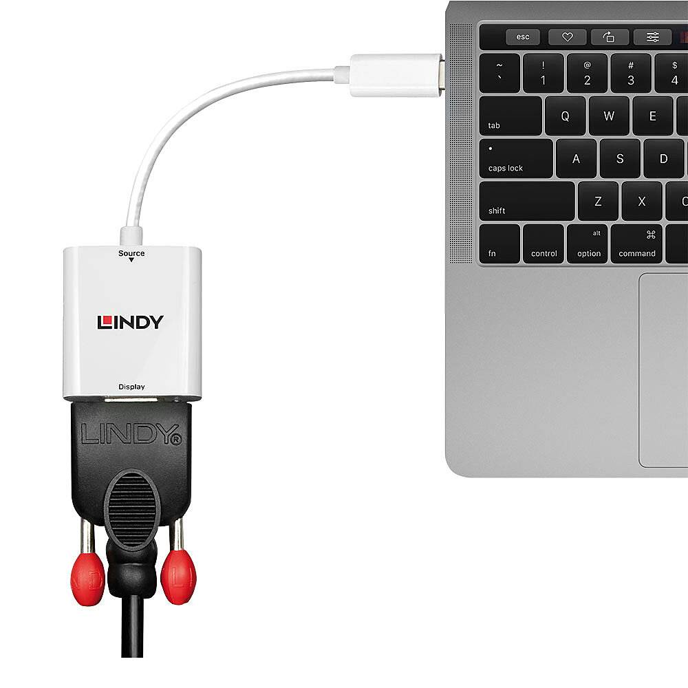 Un adattatore collega una spina del cavo VGA con un laptop moderno. A sinistra, l'adattatore è dotato di due porte audio.