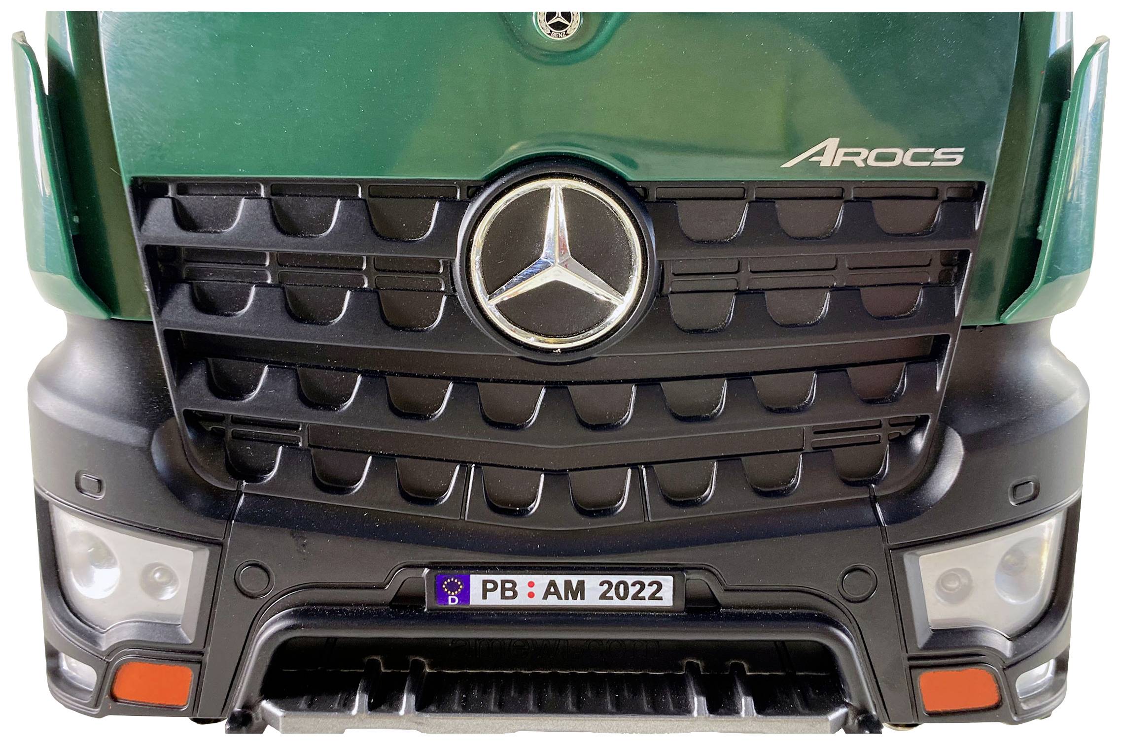 Un frontale verde di un camion con la stella Mercedes e la scritta 'Arocs', sotto il quale è presente una targa tedesca 'PB: AM 2022'.
