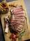 Tagliata di manzo su tagliere di legno con patatine fritte, pomodori e rosmarino.