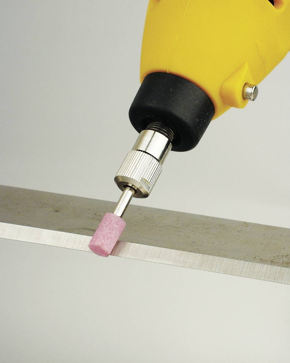 Trapano giallo con accessorio rosa per levigatura che lavora un bordo metallico.