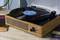 Giradischi in stile legno con un disco in vinile nero su un tavolo; accanto sono visibili altre due copertine di dischi.