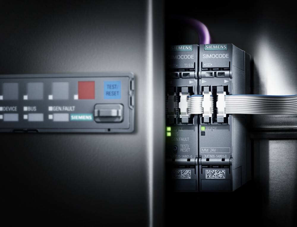Vista di un quadro elettrico con moduli Siemens SIMOCODE interconnessi. Un LED verde è acceso.