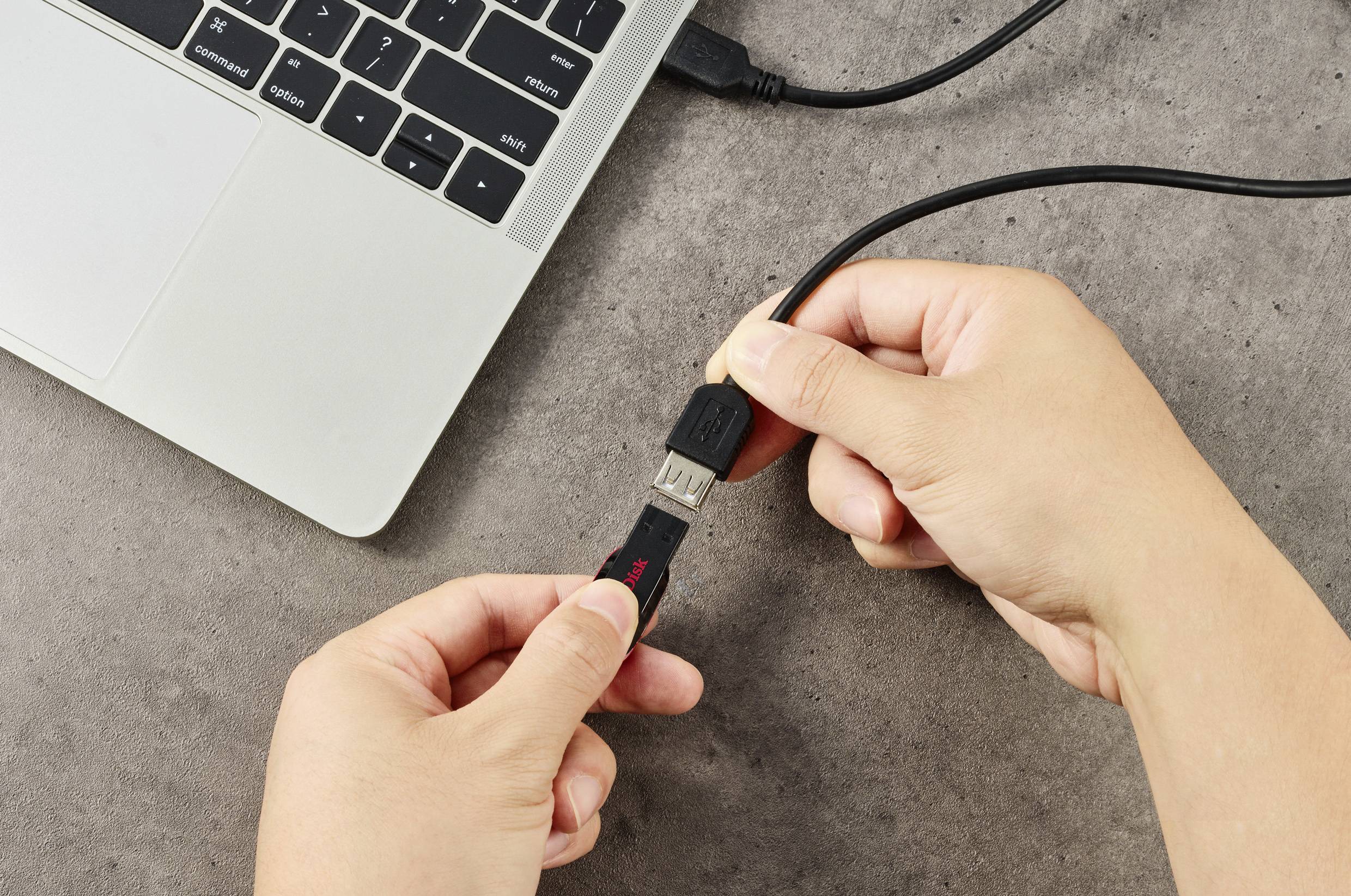 Una mano inserisce un cavo USB in un laptop.