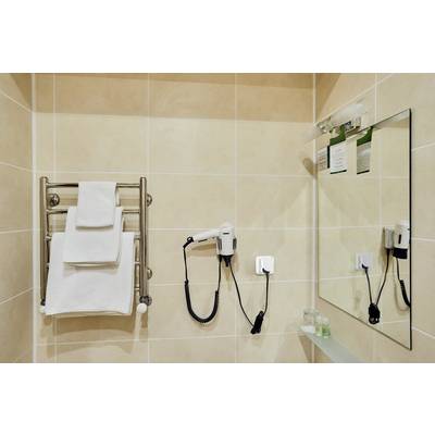 Bagno con portasciugamani, asciugamani bianchi, asciugacapelli a parete e specchio.