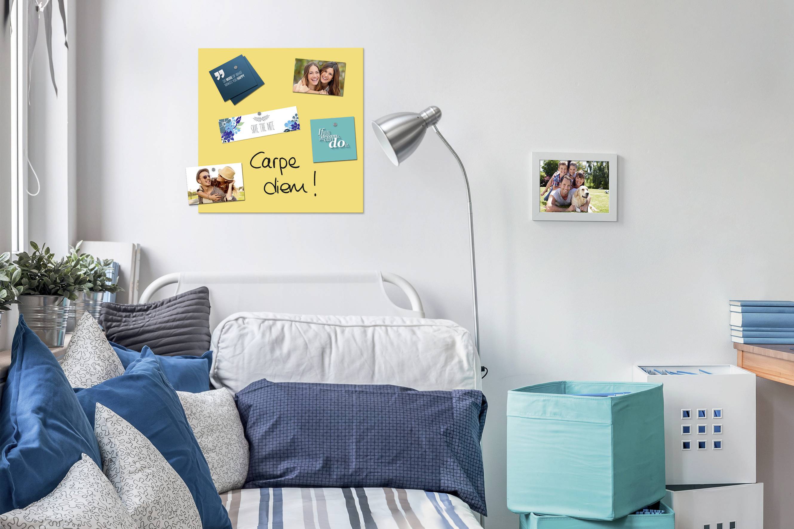 Camera con un letto, decorata con cuscini blu. Sulla parete un poster con foto e la scritta 'Carpe diem!'.