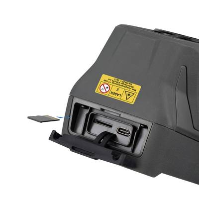 Un dispositivo nero con un'etichetta di avvertenza gialla. Ha slot per USB-C e scheda di memoria, parzialmente estratto da un vano.