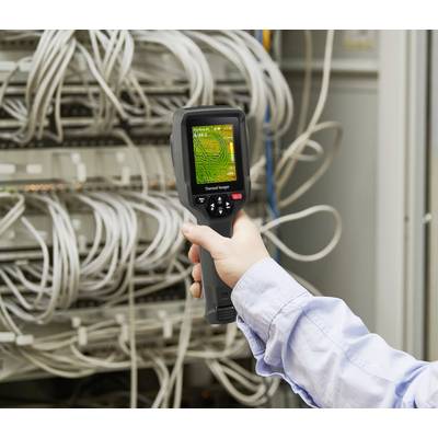 'Una persona tiene un dispositivo termografico puntato sui cavi del server in una sala di rete per verificare la temperatura.'