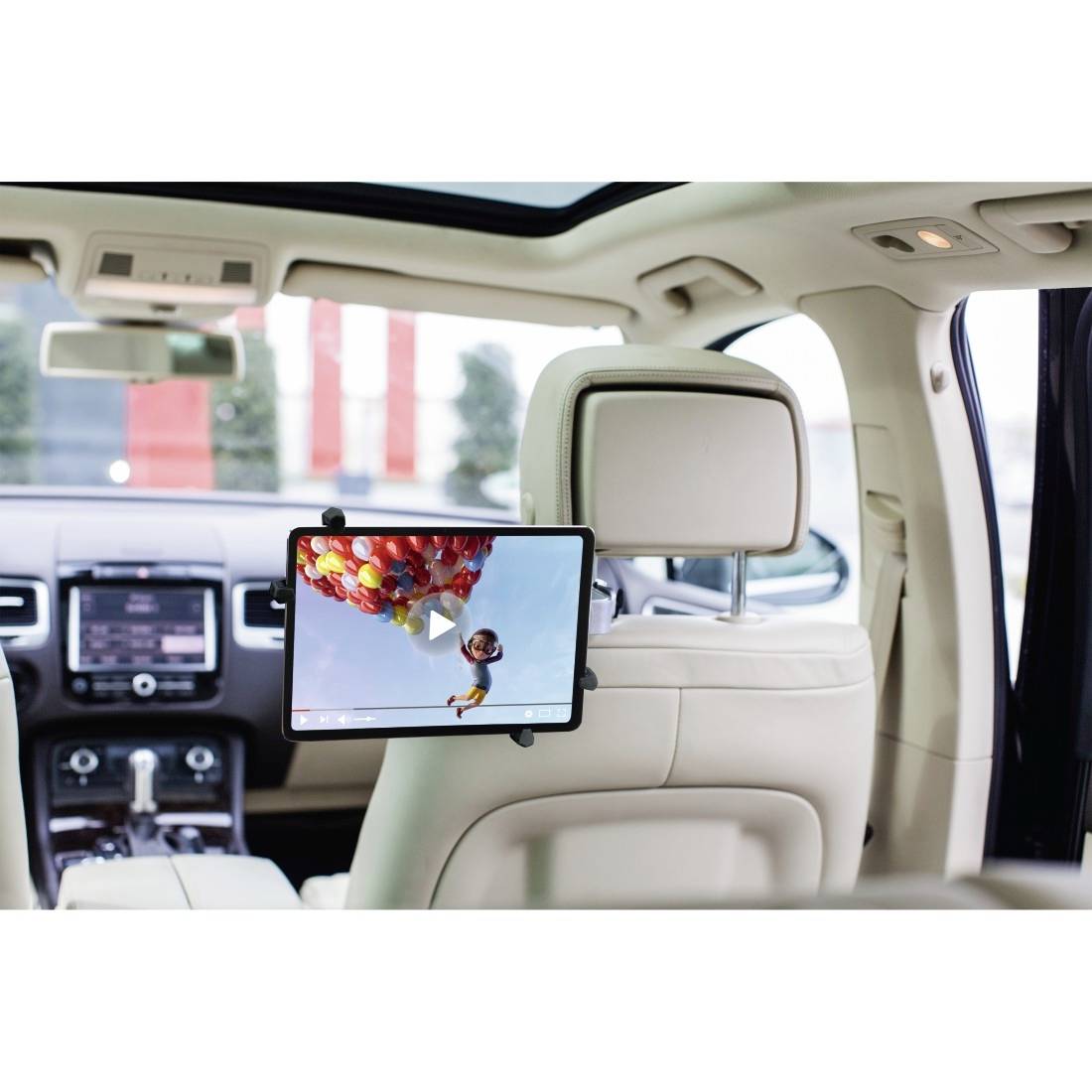 Tablet sul retro di un sedile dell'auto, riproduce un video con una persona sullo sfondo di un paesaggio con mongolfiera colorata. Sullo sfondo, l'interno dell'auto.