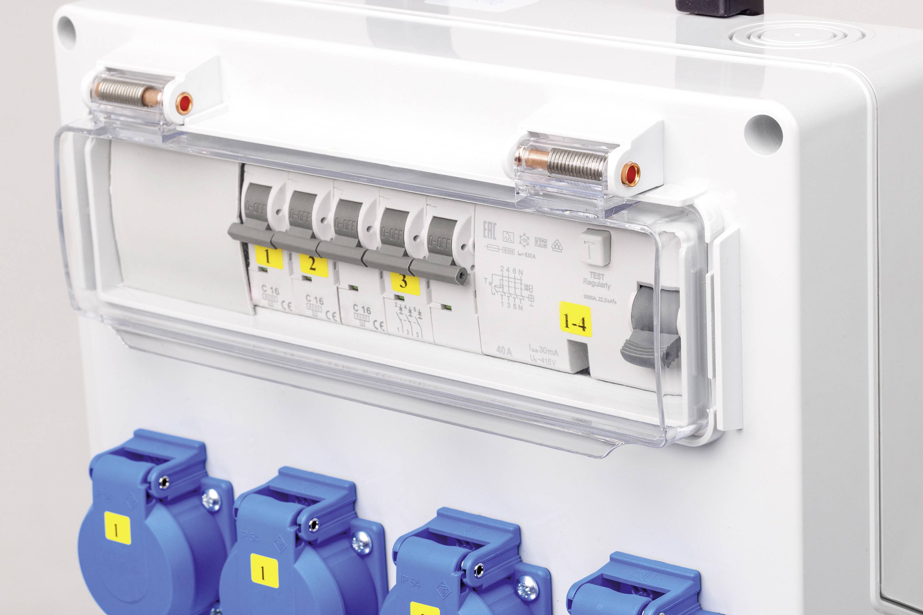 Quadro elettrico con più prese blu e interruttori di protezione, numerati da 1 a 4. Coperchio di protezione in plastica trasparente.
