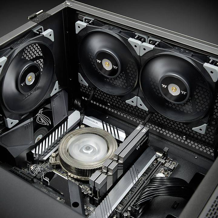 Un computer aperto con componenti interni visibili, tra cui un dissipatore di calore della CPU, ventole e una scheda madre all'interno di un case.