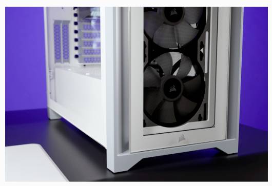 Un case per computer bianco con ventole visibili su un tavolo scuro davanti a uno sfondo lilla.