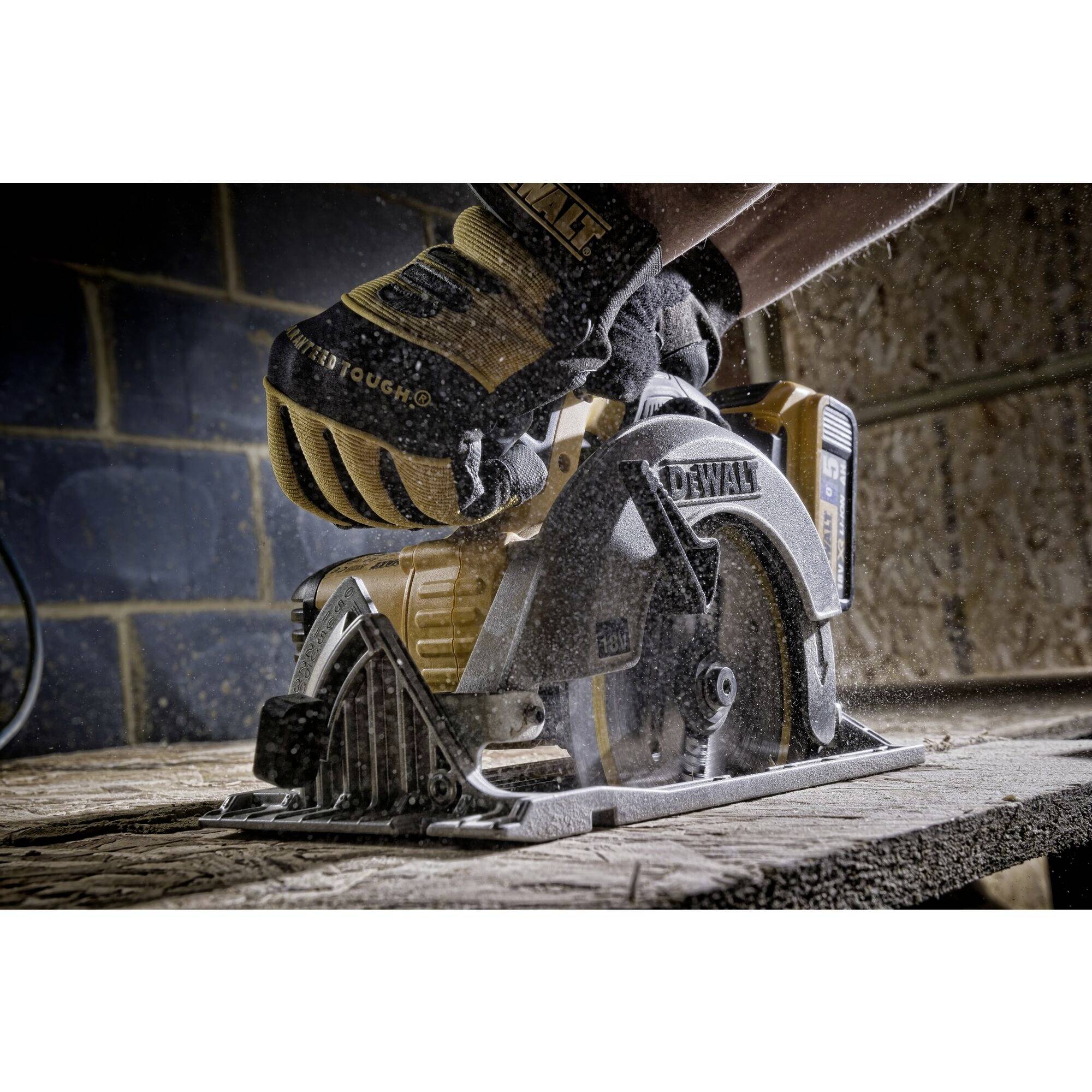 Una persona sta utilizzando una sega circolare per tagliare del legno in un laboratorio. Particelle di polvere galleggiano nell'aria.