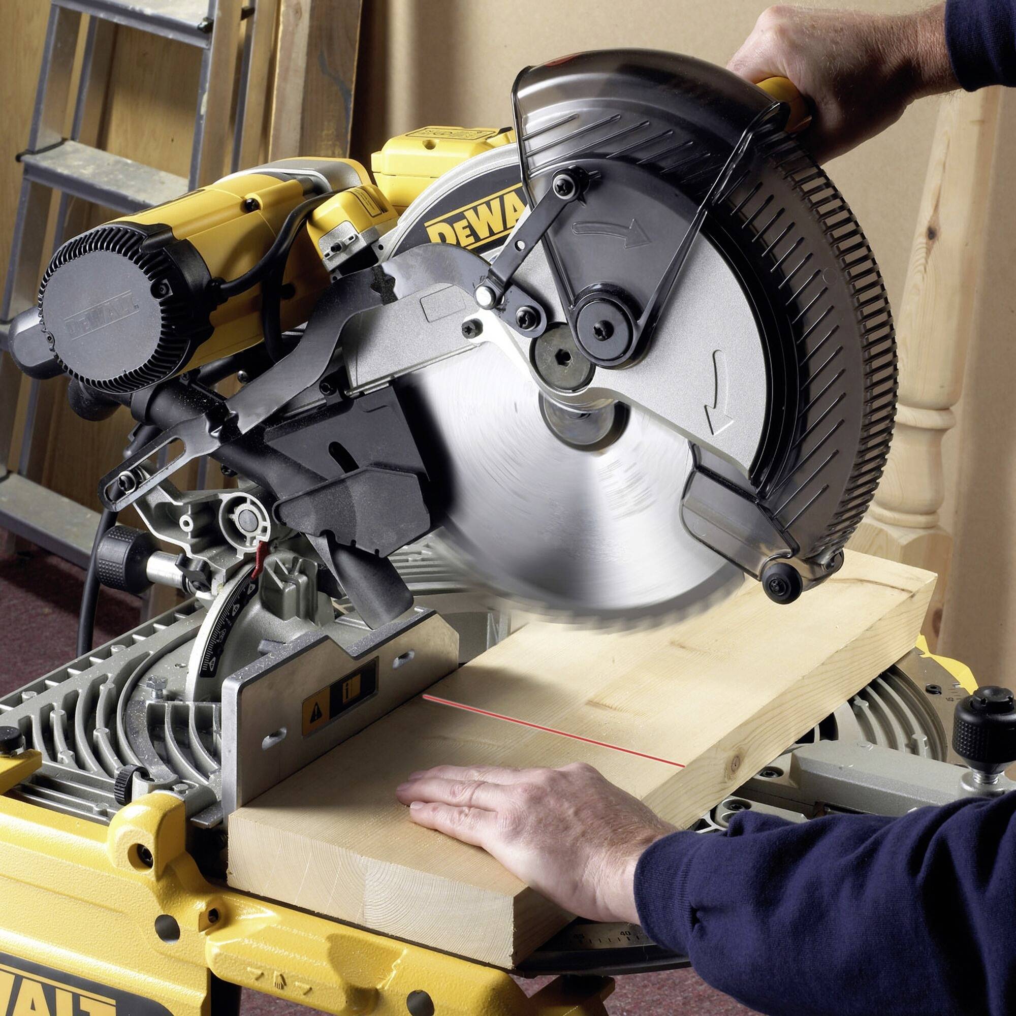 Una persona taglia una tavola di legno con una sega circolare gialla. La mano tiene fermo il pezzo mentre la sega lavora con precisione.