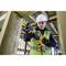 Un lavoratore edile con casco e giubbotto di sicurezza sta utilizzando un utensile elettrico per lavorare un'impalcatura di legno in un edificio in costruzione.