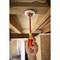 Una mano utilizza un cacciavite rosso per lavorare su un collegamento elettrico sotto un soffitto.